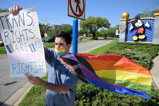 FILE - Disney cast member Nicholas Maldonado protests the company's stance on LGBTQ issues, while participating in an employee walkout at Walt Disney World on March 22, 2022, in Lake Buena Vista, Fla. For many of those who live in Florida, recent months in 2023 have brought some changes — many linked to Gov. Ron DeSantis. “Don’t say gay.” Regulation of books and classroom discussion. Teachers, parents and school librarians are all navigating new and uncertain ground. LGBTQ+ rights under attack. A very public spat between the state government and Disney. And at the center of it all is DeSantis, who has emerged as a rival of former President Donald Trump and likely has his eyes set on the White House. (AP Photo/Phelan M. Ebenhack, File)