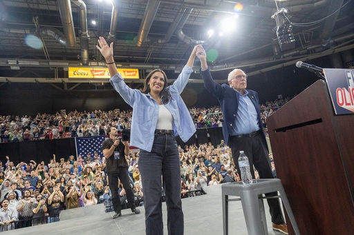 Rep. Alexandra Ocasio-Cortez, D-N.Y., holds hands with Sen. Bernie Sanders, I-Vt., during a "Fighting Oligarchy" event at the Ford Idaho Center in Nampa, Idaho, Monday, April 14, 2025. (AP Photo/Kyle Green)