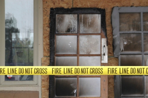 The charred doors that used to make up the entrance to the Republican Party of New Mexico headquarters are propped up behind yellow caution tape in Albuquerque, New Mexico, Monday, March 31, 2025. (AP Photo/Susan Montoya Bryan)